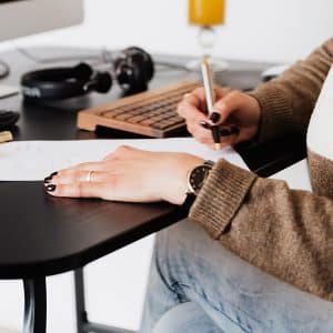 Person signing contract seated at a desk.